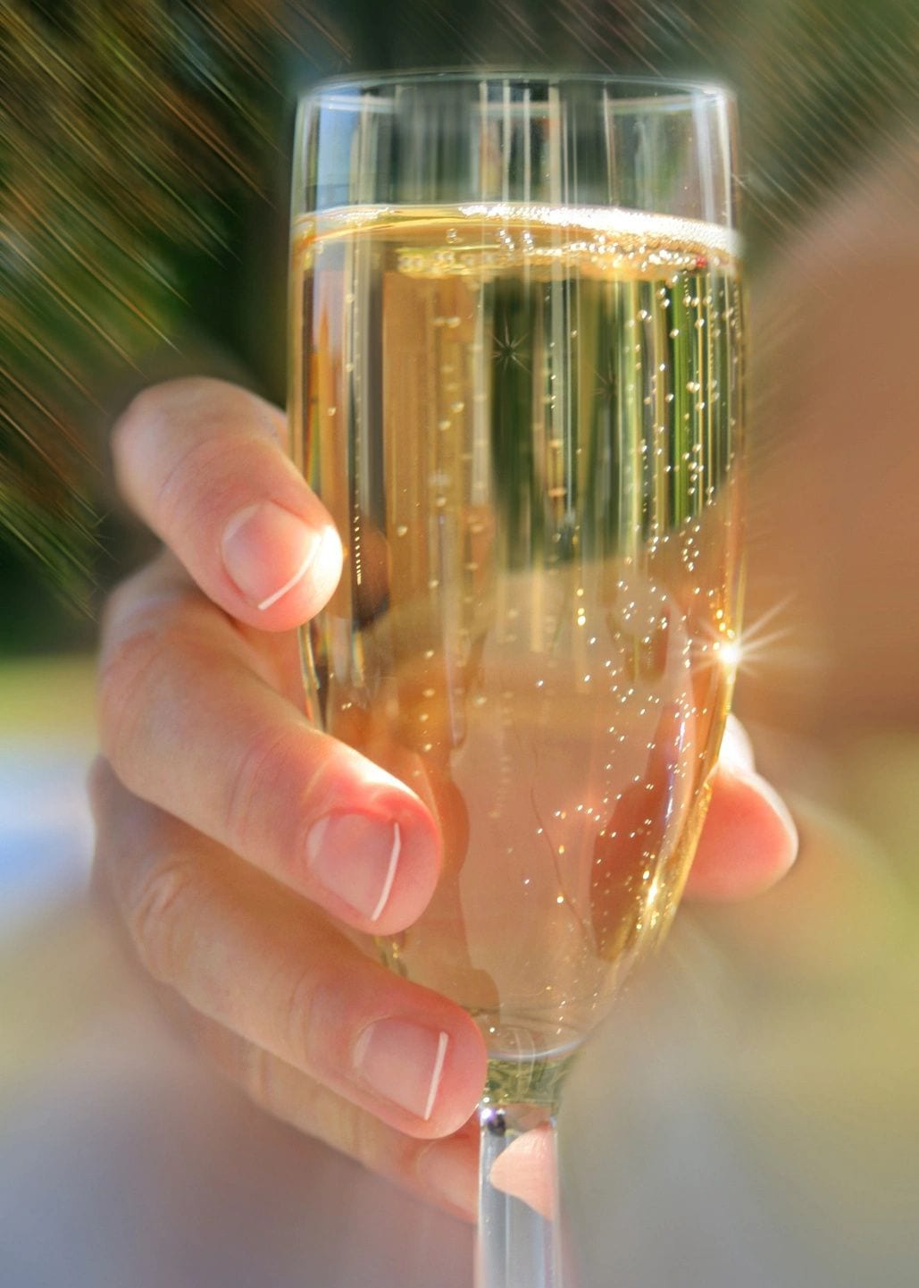 A person holding a glass of champagne in their hand.